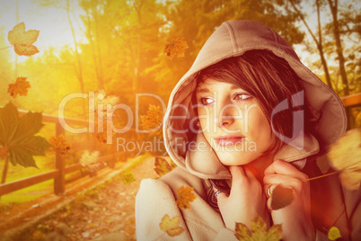 Composite image of beautiful woman wearing winter coat looking a