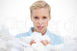 Composite image of blonde woman sneezing holding lots of tissues