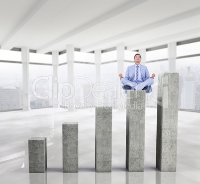 Composite image of calm businessman meditating in lotus pose