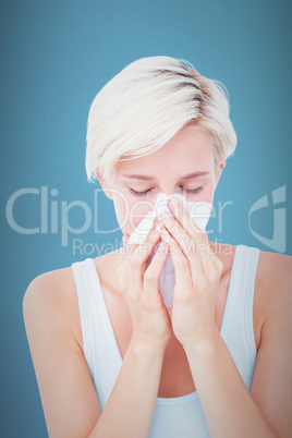 Composite image of sick woman blowing her nose