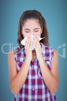 Composite image of beautiful woman sneezing in a tissue