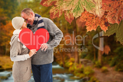 Composite image of happy mature couple in winter clothes holding