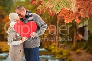 Composite image of happy mature couple in winter clothes holding