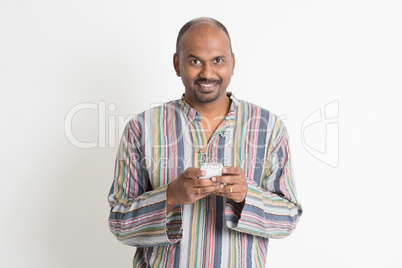 Mature casual Indian man using mobile apps