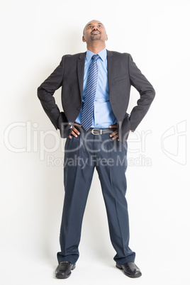 Full length mature Indian businessman looking up