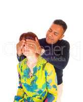 Man holding his hands on wife's eye's.
