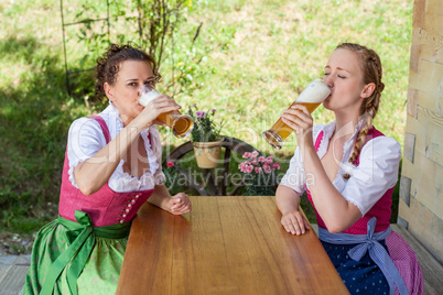 Zwei Frauen im bayerischen Dirndl beim Bier trinken