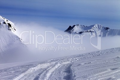 Ski slope in fog at sun day