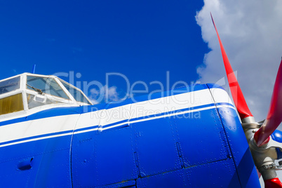 Seitenansicht eines blauen Flugzeugs mit rotem Propeller