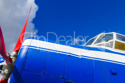 Seitenansicht eines blauen Flugzeugs mit rotem Propeller