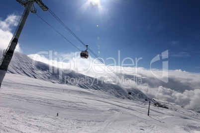 Gondola lift and ski slope at nice sunny day