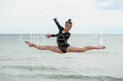 Gymnast Dancer Jumping On The Sea Beach