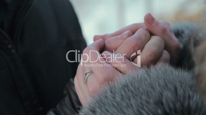 Girls warms hands boyfriend, frozen in the cold