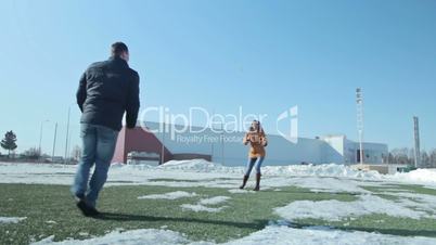 Couple playing and running on the football football field