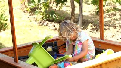 Little cute girl playing in sandbox