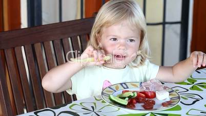 Sweet little blonde girl having lunch