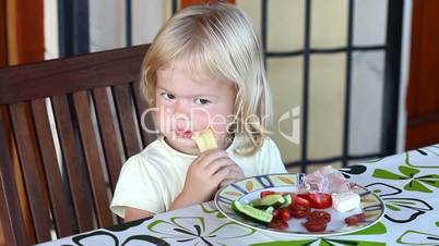 Sweet little blonde girl having lunch