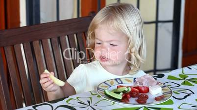 Sweet little blonde girl having lunch
