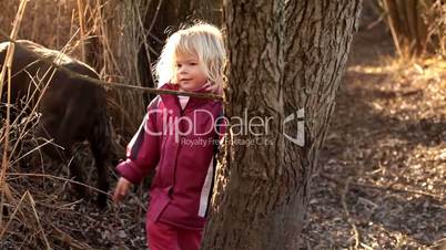 Adorable little girl playing with a twig in the nature in winter