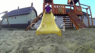 Little girl playing on a slide in winter