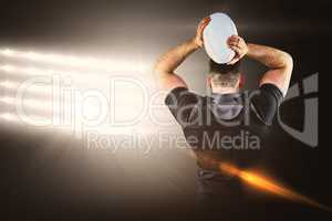 Composite image of tough rugby player throwing ball