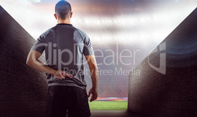 Composite image of rear view of rugby player with fingers crosse