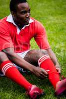 Rugby player sitting on grass