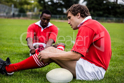 Rugby players sitting on grass before match