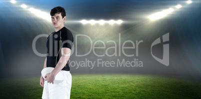 Composite image of rugby player holding a rugby ball