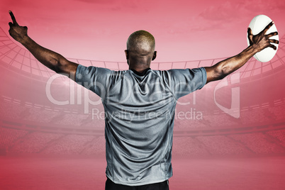 Composite image of rear view of sportsman with arms raised holdi