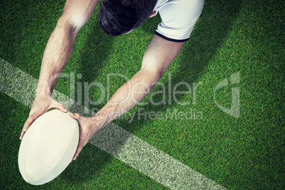 Composite image of high angle view of man holding rugby ball wit