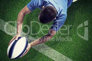 Composite image of rugby player lying in front with ball