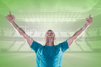 Composite image of happy rugby player with arms raised