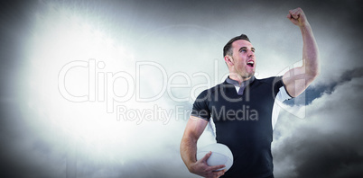 Composite image of rugby player cheering with the ball