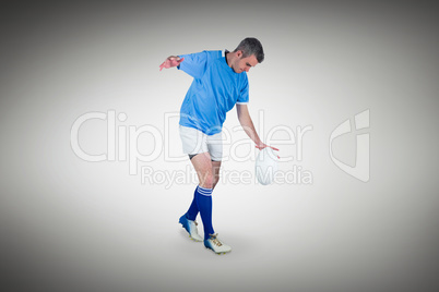 Composite image of rugby player kicking a rugby ball