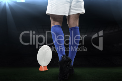 Composite image of low section of rugby player going to kick the