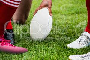 Rugby players in huddle with ball