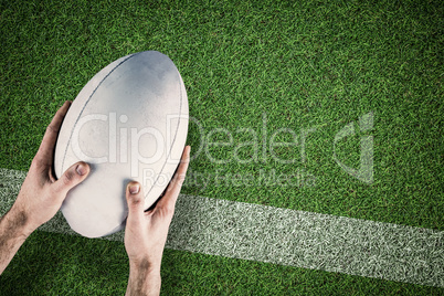 Composite image of a rugby player posing a rugby ball