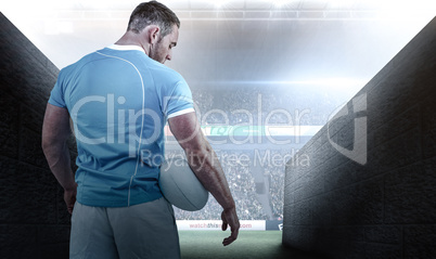 Composite image of rugby player standing with ball