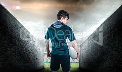 Composite image of back turned rugby player holding a ball