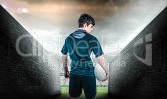 Composite image of back turned rugby player holding a ball