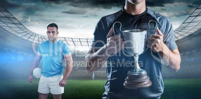 Composite image of victorious rugby player holding trophy