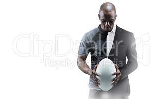 Composite image of thoughtful athlete looking at rugby ball