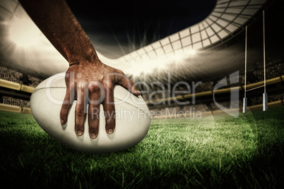 Composite image of close-up of sports player holding ball