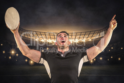 Composite image of rugby player cheering with the ball