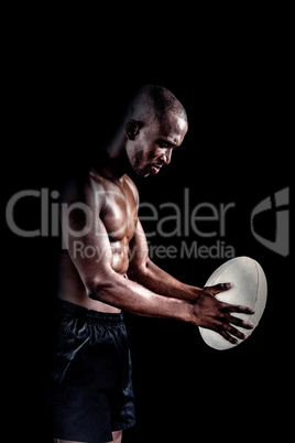 Shirtless athlete playing with rugby ball