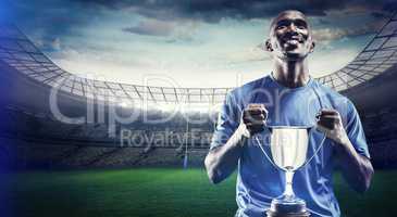 Composite image of happy athlete holding trophy looking up