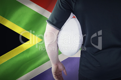 Composite image of rugby player holding a rugby ball