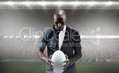 Composite image of thoughtful athlete looking at rugby ball