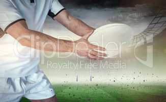 Composite image of midsection of rugby player holding the ball